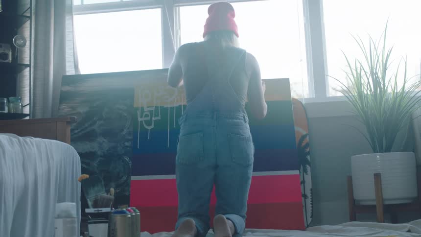 A woman painting on a canvas in a room