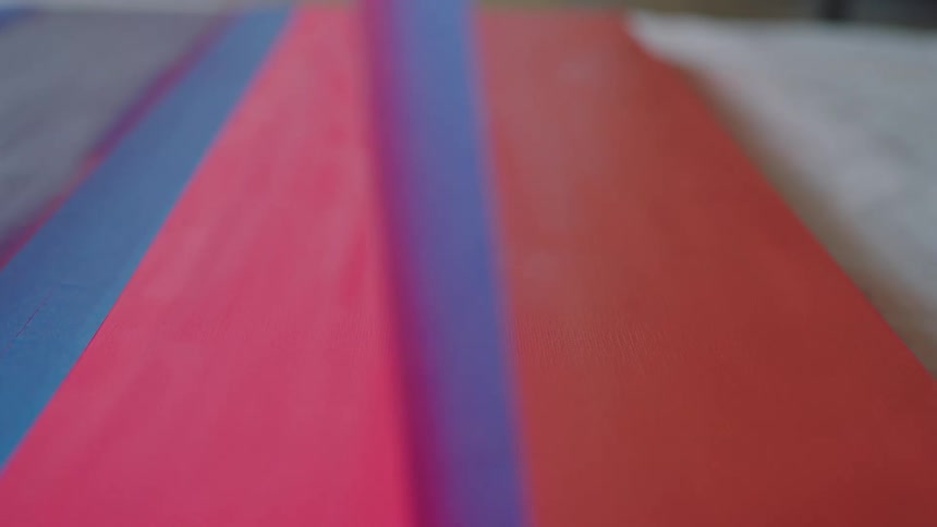 A piece of tape is pulled from the paint