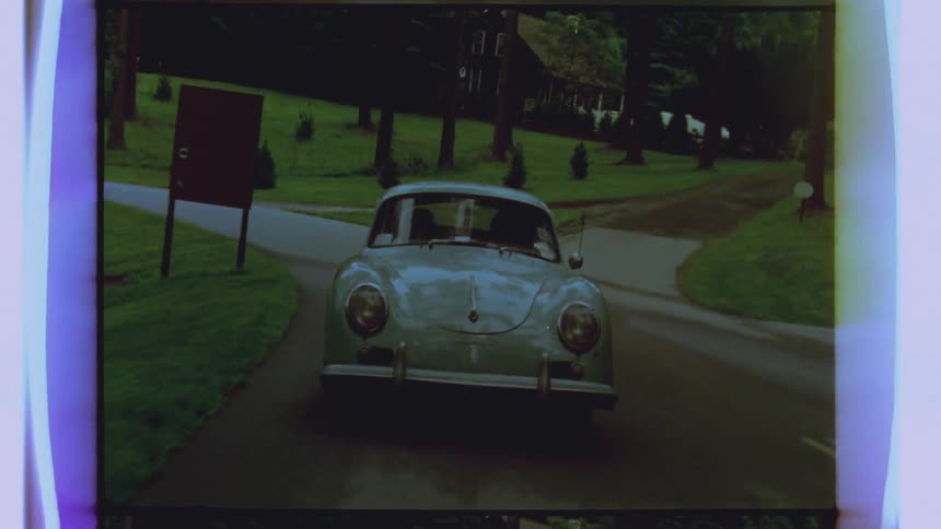 An old vehicle drives down a windy road