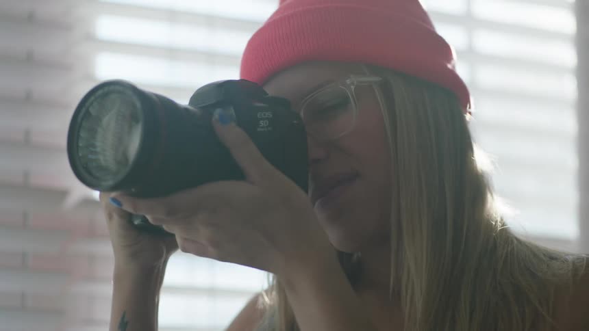 Woman manipulates camera before examining photo taken