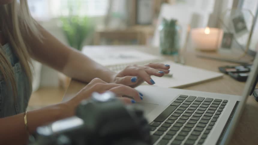 A woman takes notes on paper after using her laptop