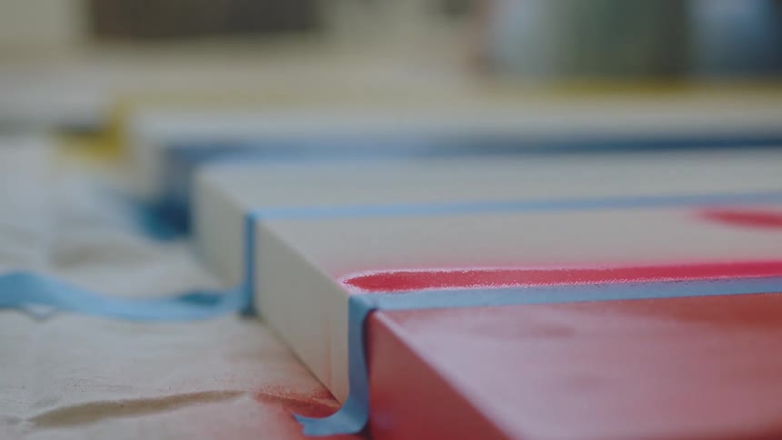 Woman paints a canvas using a spray can of paint