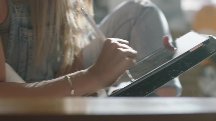 A woman sketching on a tablet