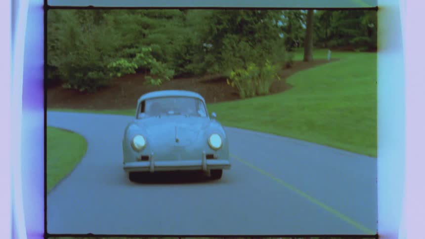 A small car is driving down a road