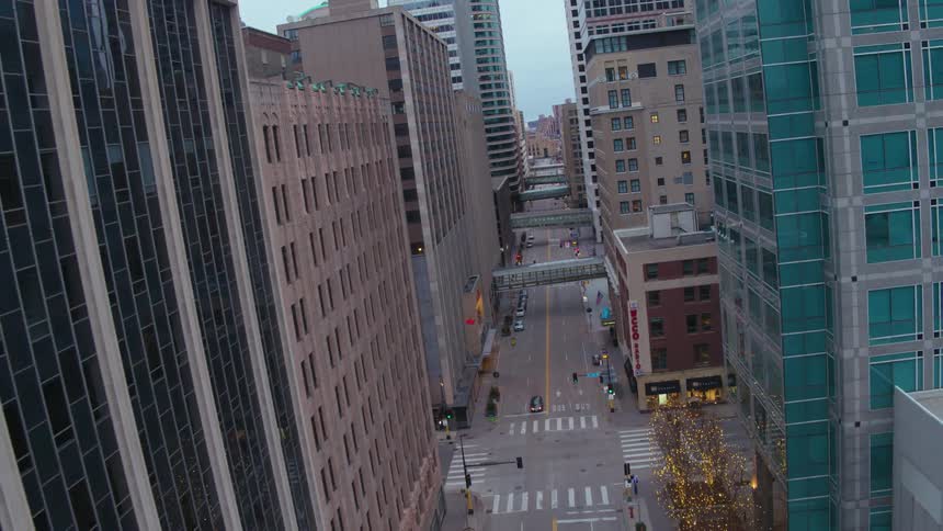 A car travels on the street inbetween the skyscrapers in the city
