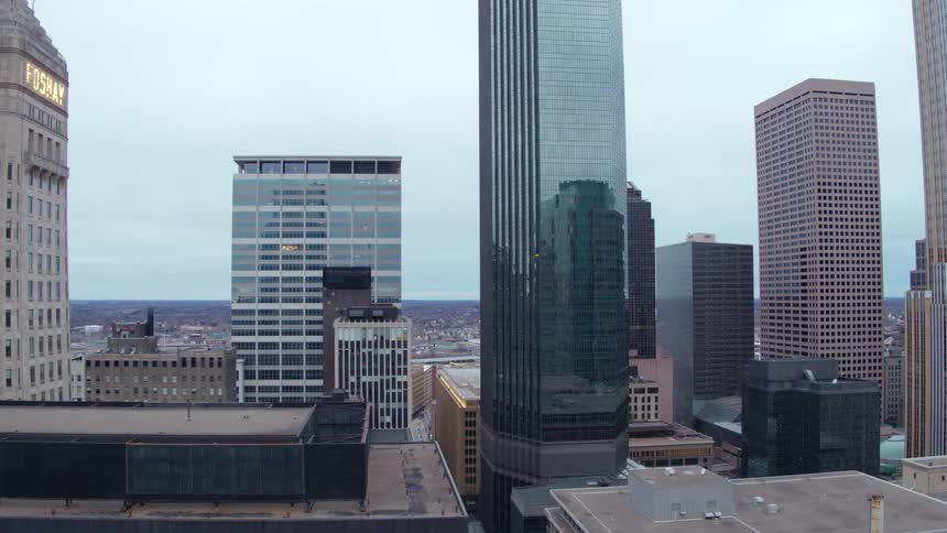 Skyscrapers stand tall above rooftops and streets in a city