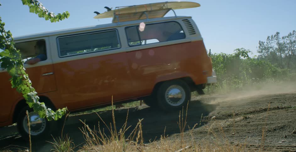A van takes a turn onto a vineyard dirt road