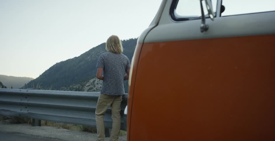 A couple of people are stopped on the side of the road looking out over the valley