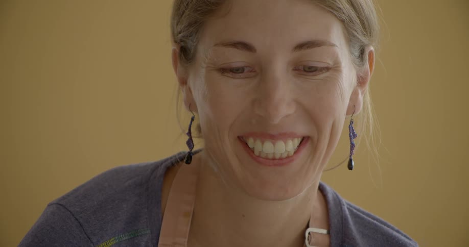 A woman wearing blue earrings smiles