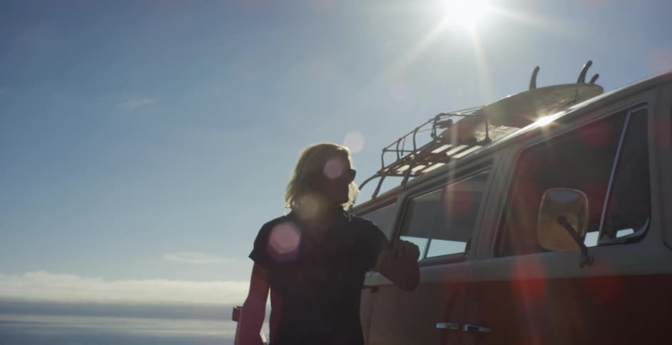 Man leaning against a van on the beach