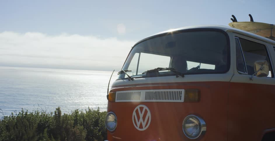 The orange van drives past the coast
