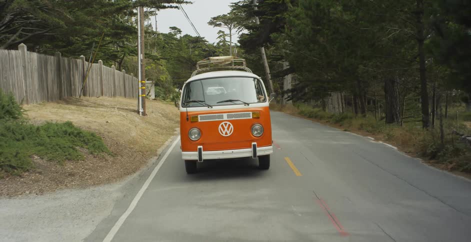 A volkswagen bus is driven on a street