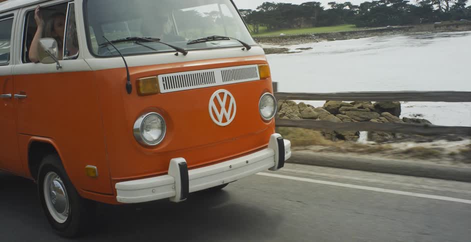 A van travels on a road along the shore