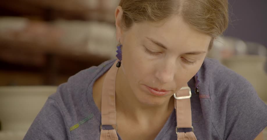 A woman is working on something as she looks down