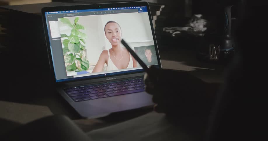A man and woman have a conversation via video conference on a laptop computer