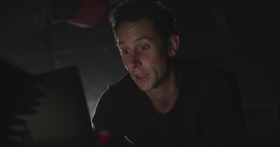 A man sits and talks with someone on a laptop