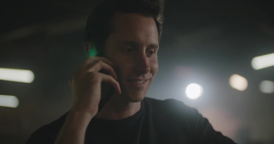A man smiles as he talks to someone on his cell phone