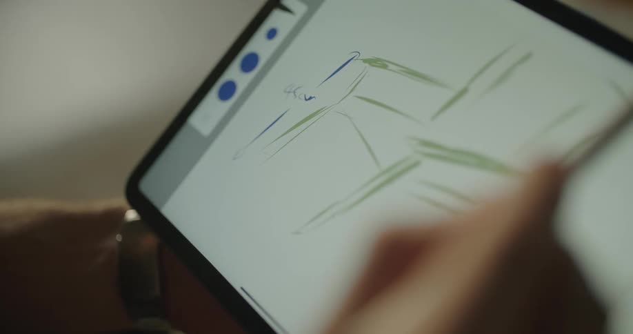 A man makes a sketch of a chair using a stylus on his tablet computer