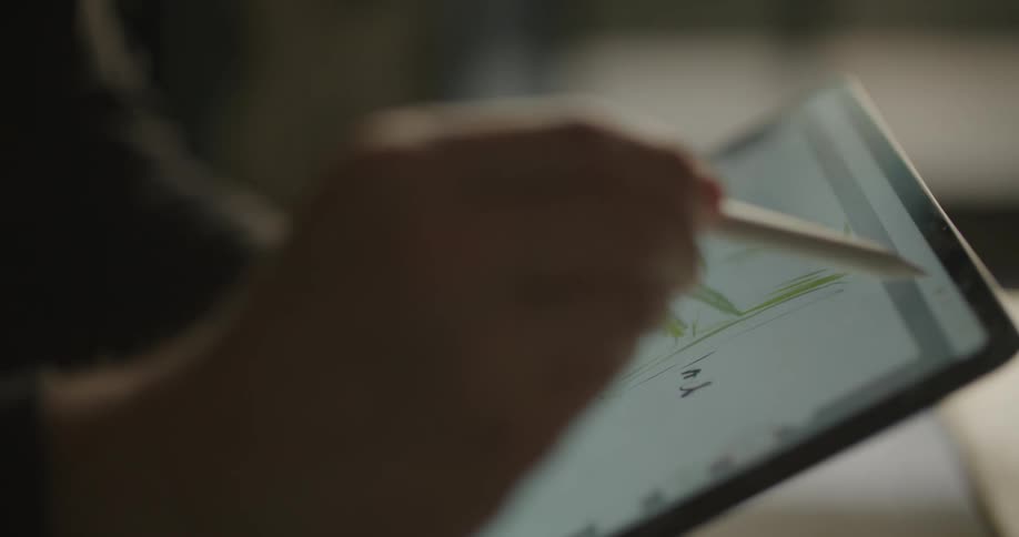 A person draws with a stylus on a tablet