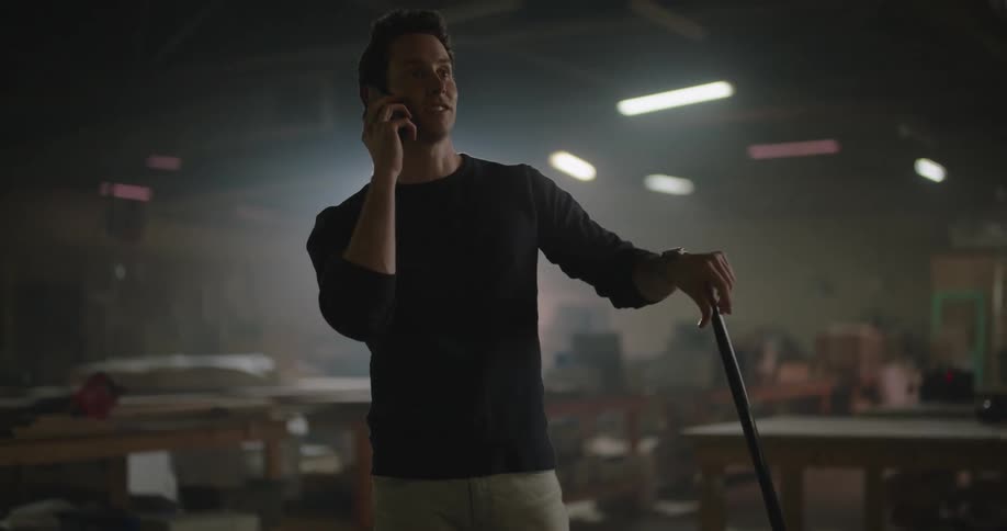 An employee talking on the phone while sweeping the floors