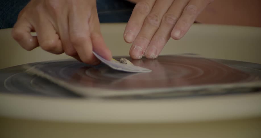 A person removes clay from a wheel