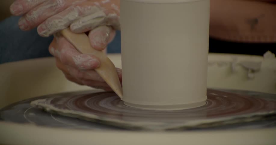 A person is spinning clay on a wheel