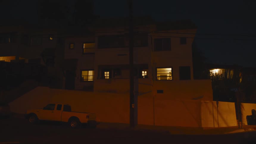 A truck is parked on the corner near the home