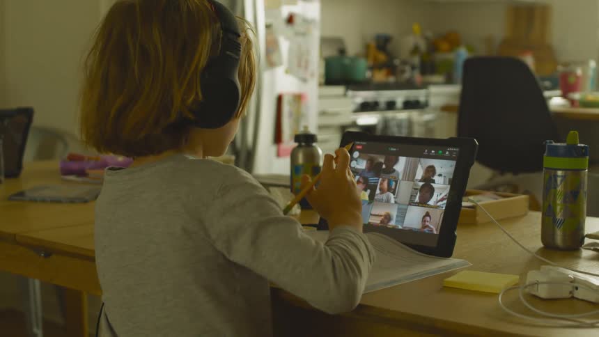 A child is participating in an online class