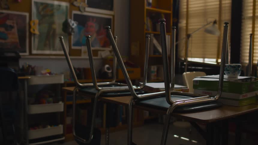 Two chairs are set on a wooden tabletop in a room