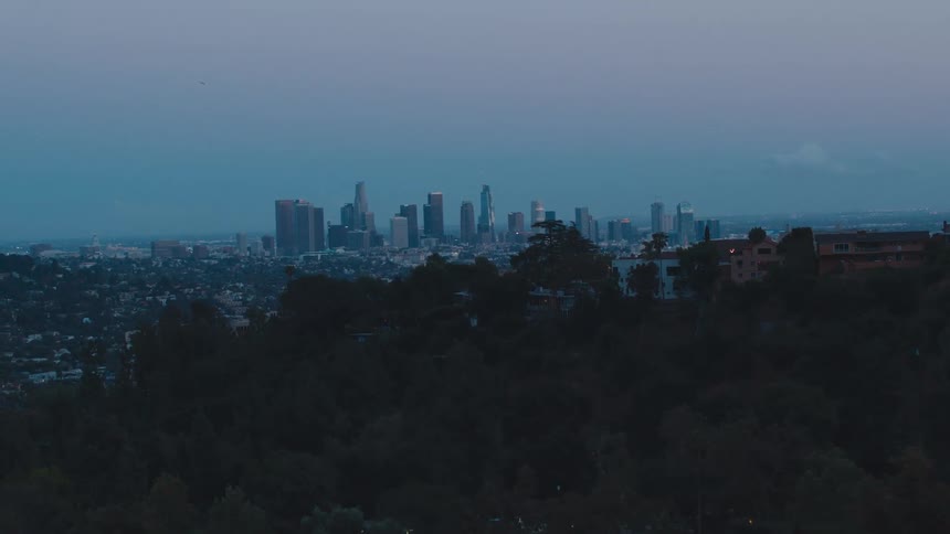Skyscrapers loom in the distance in the evening