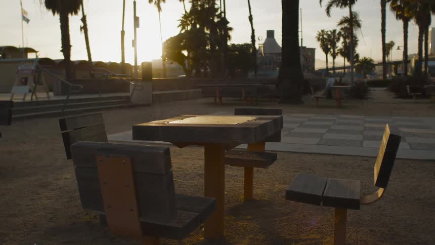 A game table is empty in a park at sunrise