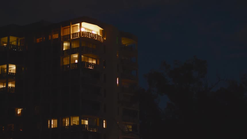 A view of an apartment building outdoors at night