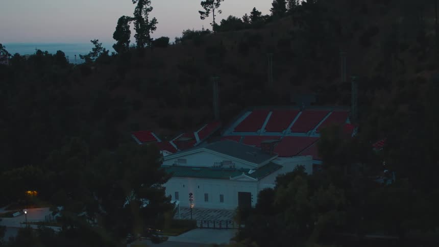 A building with stadium seating outside nestled in the trees