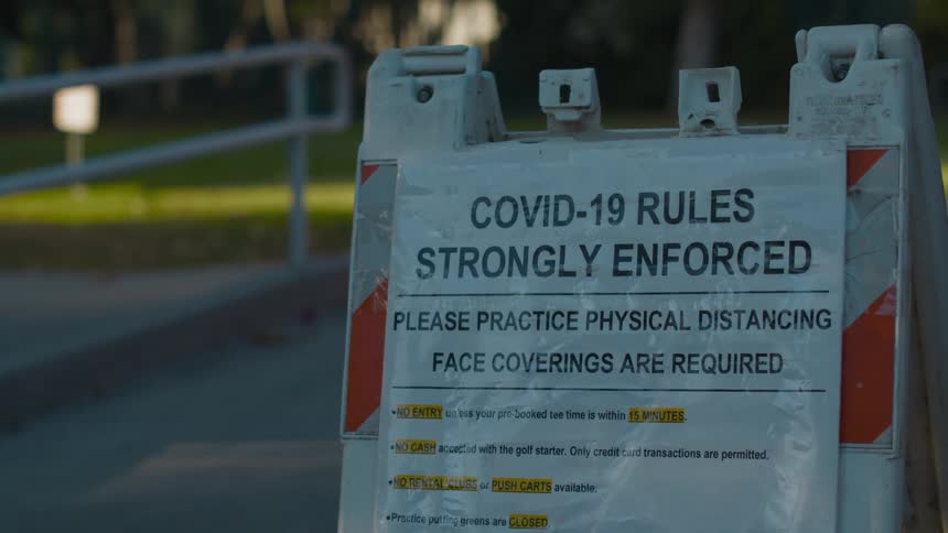 A warning blockade with a covid rules sign attached