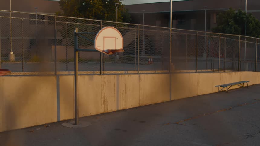 Basketball hoop on a public park in a small town at sunset