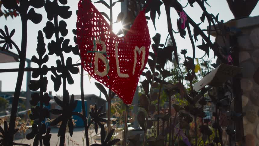 A knit hanging from a gate outdoors during the day