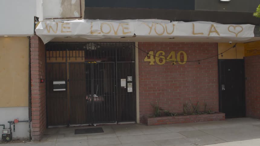 Building with a sign and a street address sits in the city