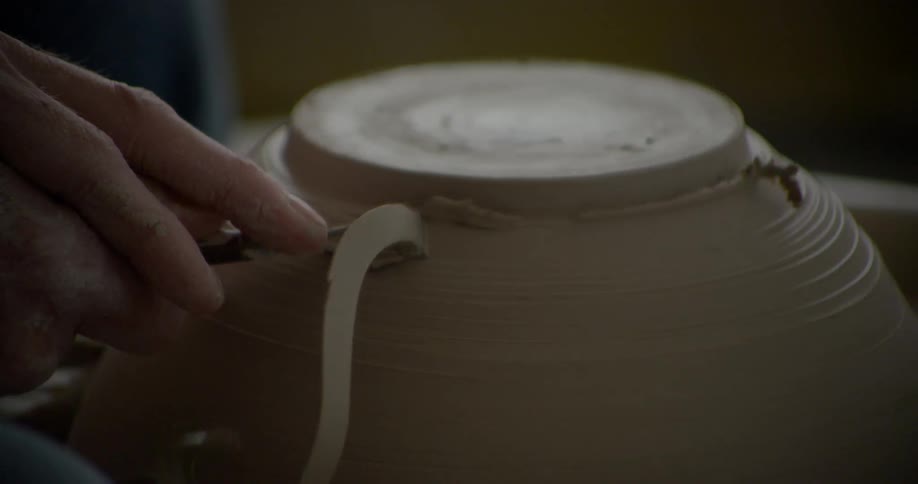 A person is shaving a bowl as it spins