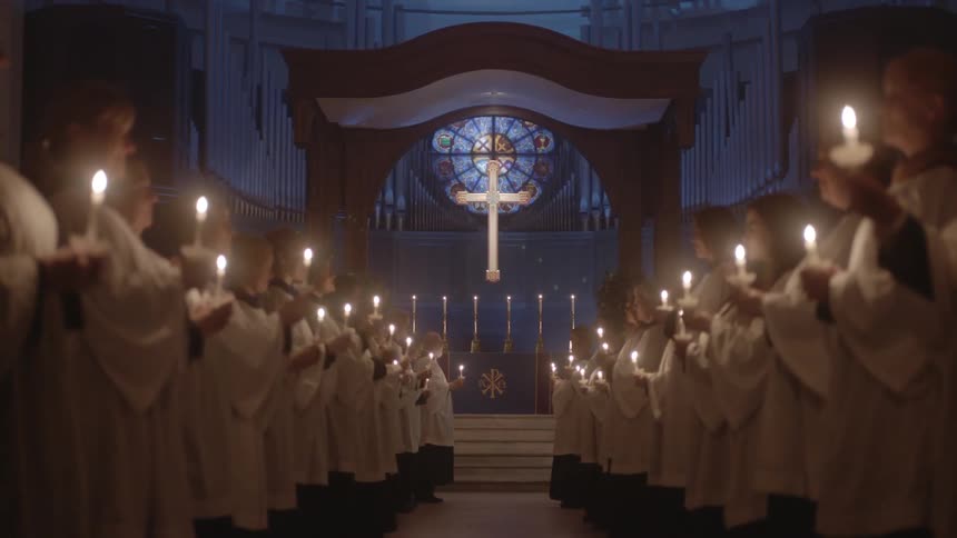 A church procession holds candles during a service