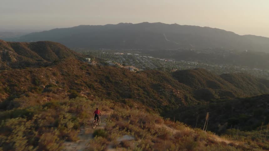 A man rides a mountain bike down a hill