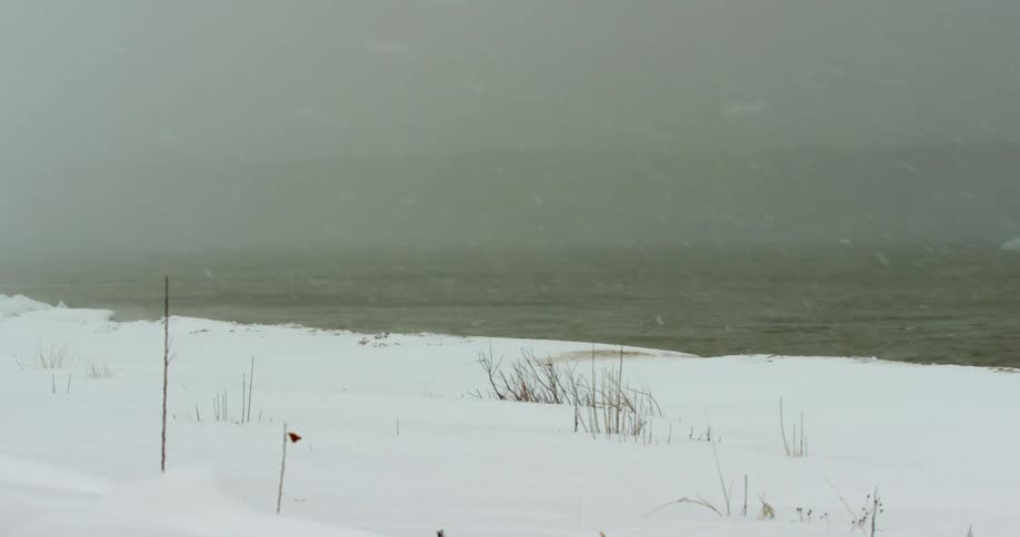 Snow storm blowing over a lake at daytime