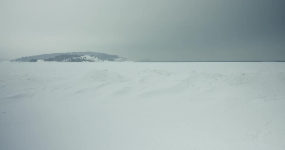 Snow covered ground under a gray winter sky