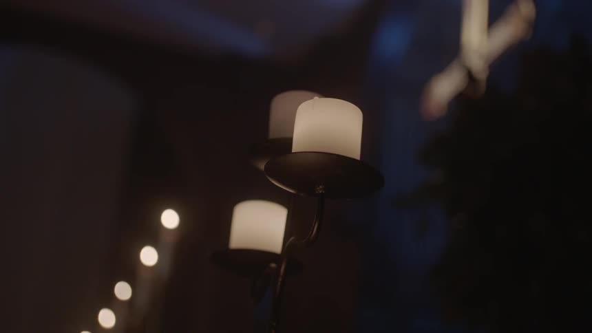 A lit candelabra glows in a church