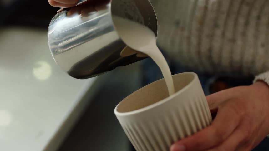 A person is pouring a beverage into a cup