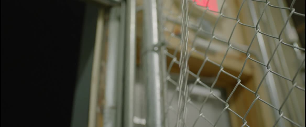 Person standing next to chain link pulls chain down to lift roll up door