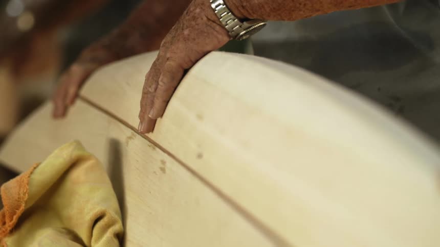 A man is checking the side of an object on the counter