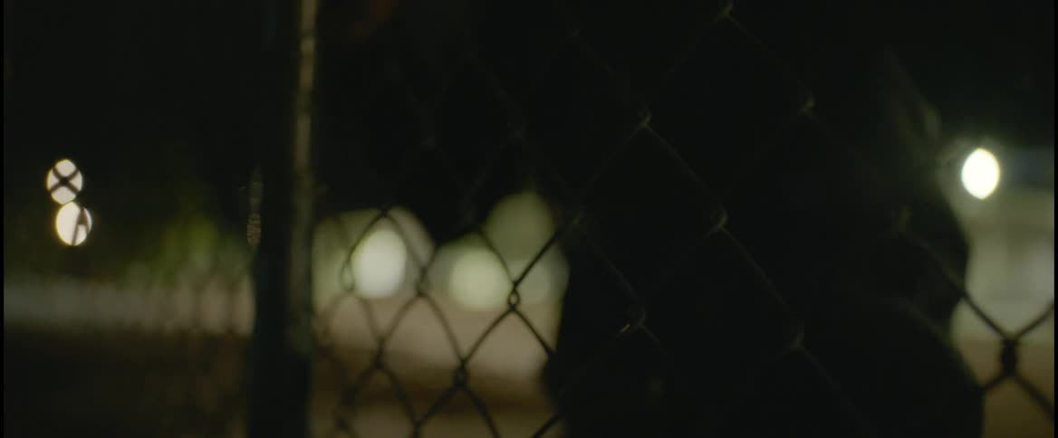 A man is climbing the fence near the building