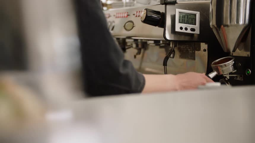 An employee putting coffee into a machine