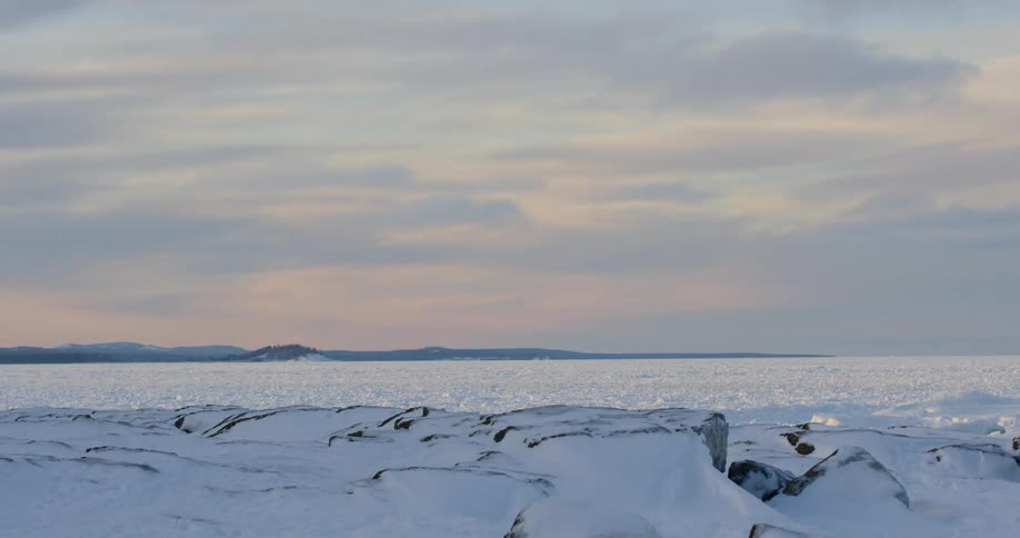 A landscape covered in ice and snow with the sky and clouds in the background