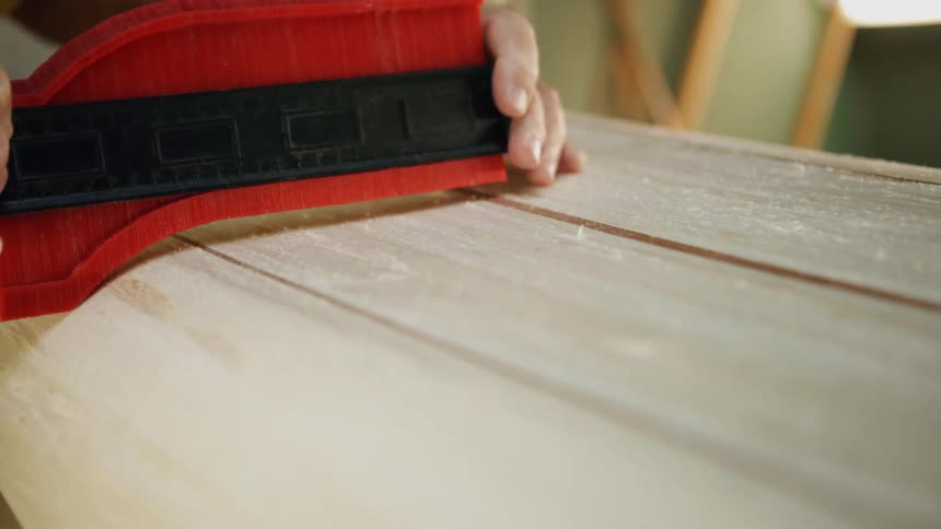 A man is using a tool on a piece of wood